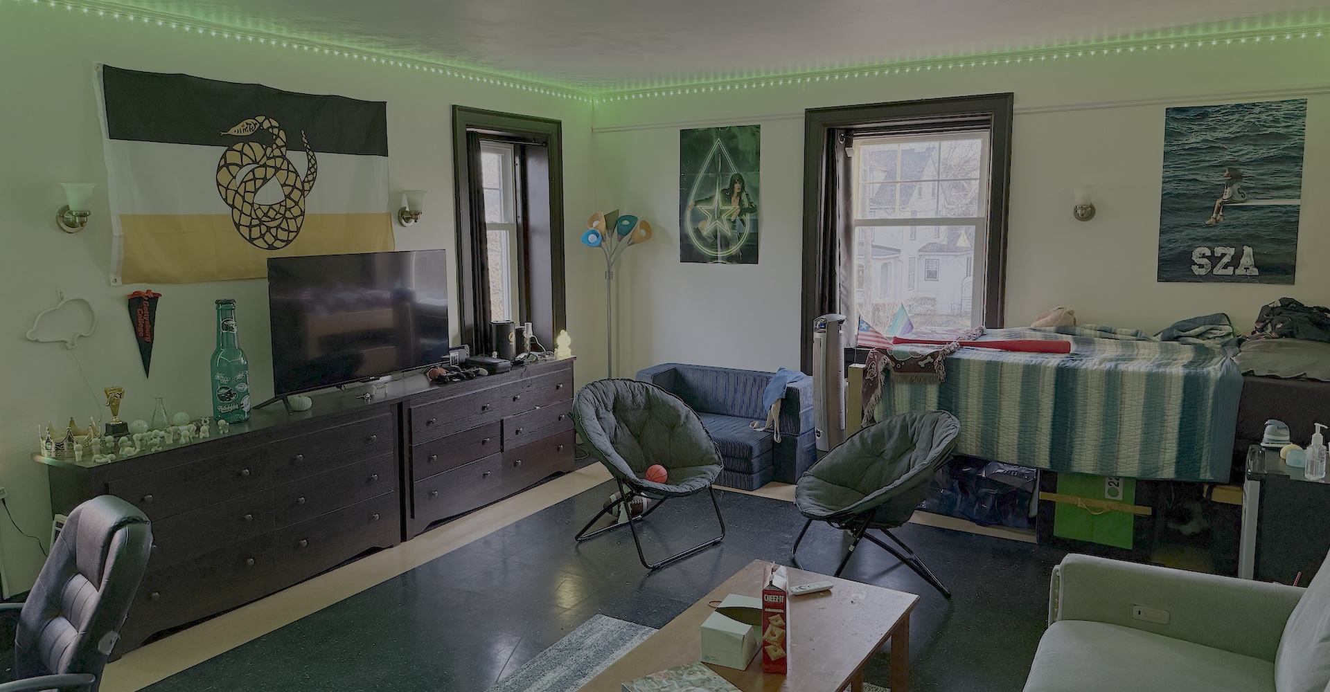 A large fraternity bedroom with LED lights and lounge setup