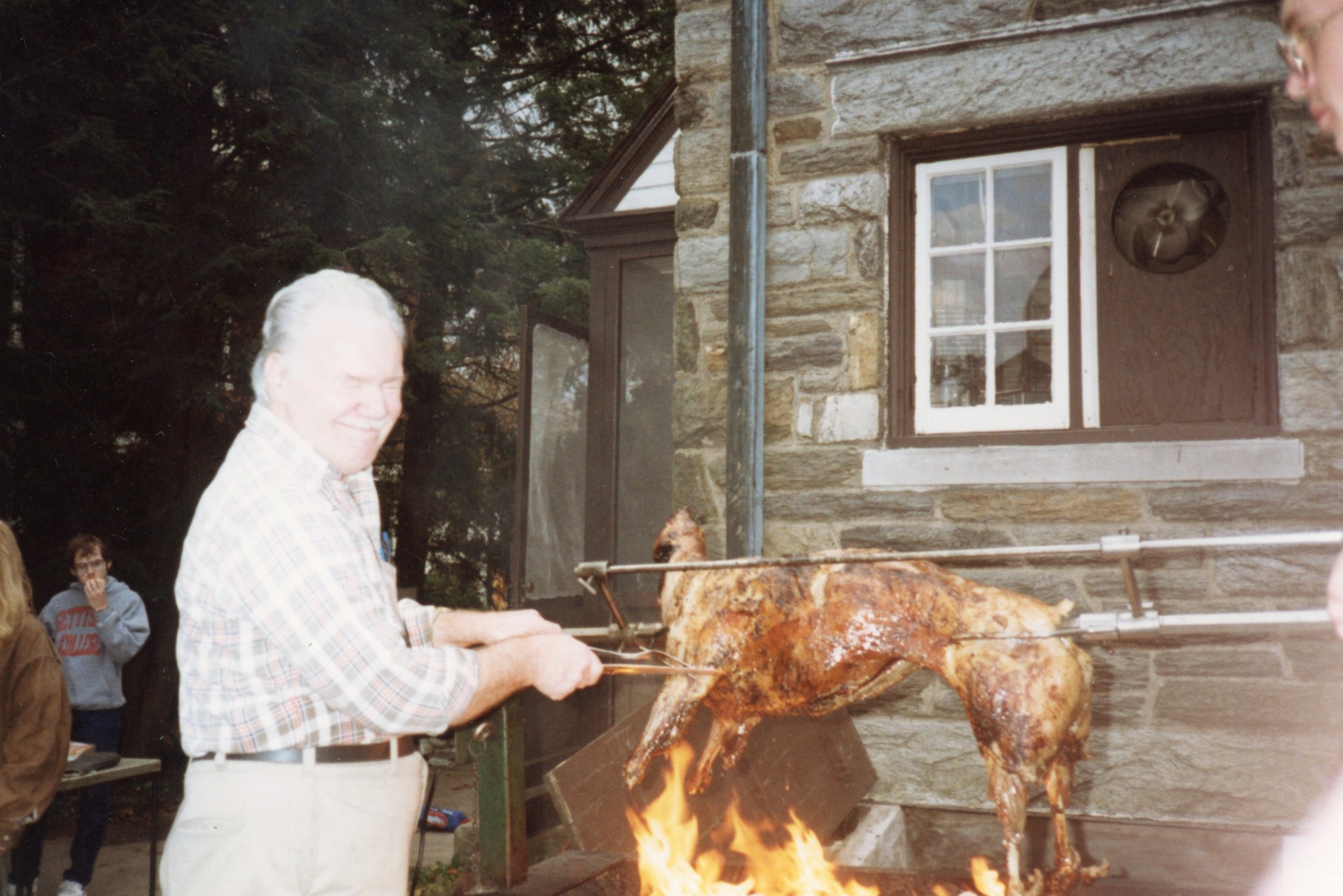 Allen Mom Dubbs tending the lamb roast outside the house