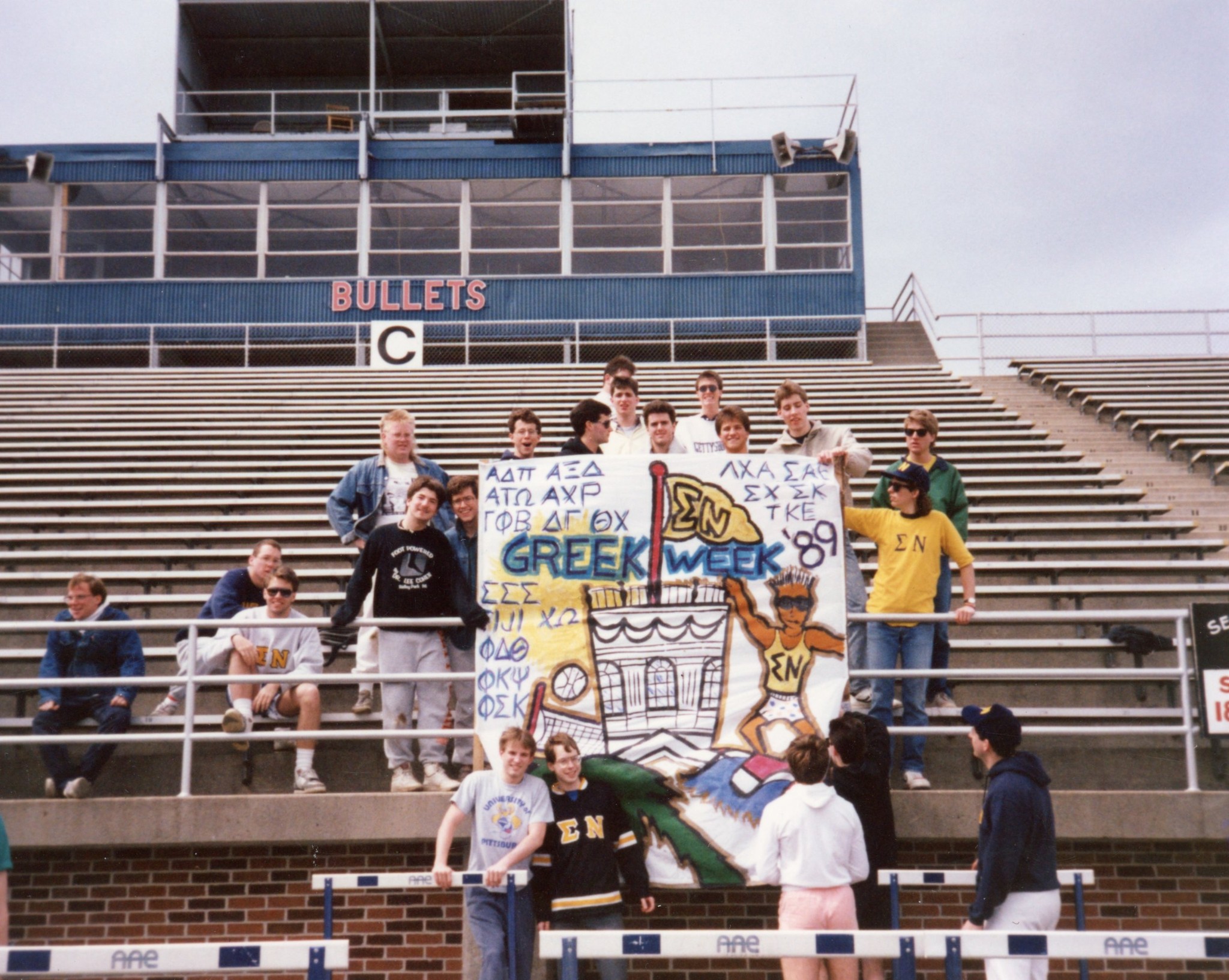 Sigma Nu brothers at Greek Week 1989 with hand-painted banner in the stadium